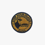 Round embroidered patch with text and a logo on a white background